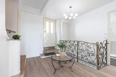 a living room with a table and a white wall at MY CASA - PONCHETTES - Independent House Promenade Des Anglais in Nice