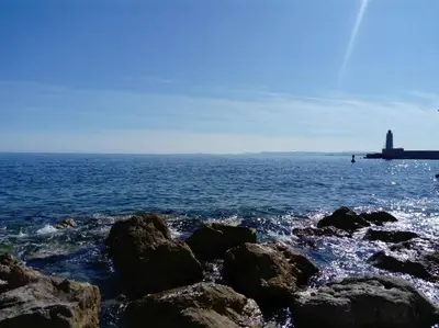 a group of rocks in the ocean with a lighthouse at Studio avec balcon à 7 min du port et de Garibaldi in Nice