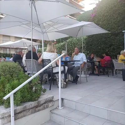 a group of people sitting at tables under white umbrellas at EXCEPTIONNEL 4 pieces vue panoramique baie des anges proche plage in Nice