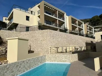 a building with a swimming pool in front of a house at Prestige View 411 By Avecoeur in Èze