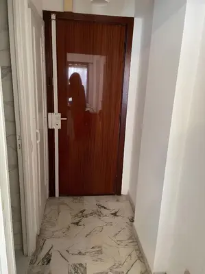 a woman standing in front of a door with a marble floor at Studio 50 m de la mer - Centre - Proche mer in Nice