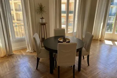 a dining room with a black table and white chairs at Nice 56m with balcony in rotunda near the sea in Nice