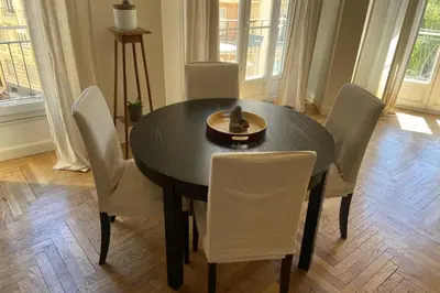 a dining room table with white chairs and a bowl on it at Nice 56m with balcony in rotunda near the sea in Nice