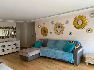 a living room with a couch and mirrors on the wall at Cagnes-sur-Mer, 50m de la mer, au calme in Cagnes-sur-Mer