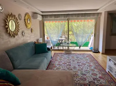 a living room with a couch and a rug at Cagnes-sur-Mer, 50m de la mer, au calme in Cagnes-sur-Mer