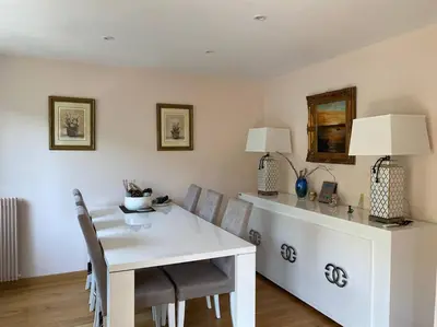 a dining room with a white table and chairs at Cagnes-sur-Mer, 50m de la mer, au calme in Cagnes-sur-Mer