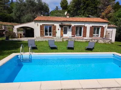 a house with a swimming pool in front of a house at Villa Olivaie St Ange in La Gaude