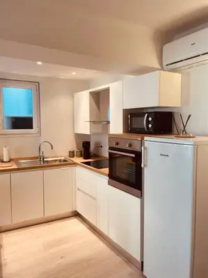 a kitchen with white cabinets and a sink and a microwave at Appartement Carré d’Or Nice in Nice