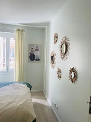 a bedroom with mirrors on the wall and a bed at Appartement Carré d’Or Nice in Nice