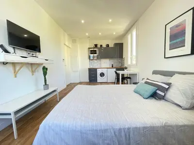 a bedroom with a large bed and a desk at Nice Renting - CAMBRAI02 - Studio Beach Sea View - AC - Promenade des Anglais in Nice