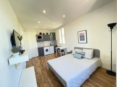 a bedroom with a large bed and a kitchen at Nice Renting - CAMBRAI02 - Studio Beach Sea View - AC - Promenade des Anglais in Nice