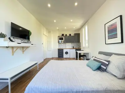 a bedroom with a large bed and a kitchen at Nice Renting - CAMBRAI02 - Studio Beach Sea View - AC - Promenade des Anglais in Nice