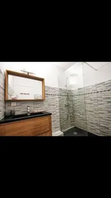 a bathroom with a shower with a mirror and a sink at Superbe appartement avec piscine l'été de juin à septembre in Nice