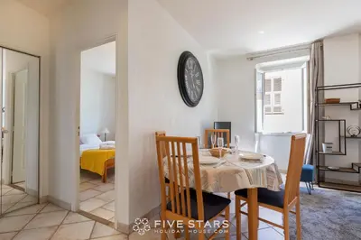 a dining room with a table and a clock on the wall at Suite La bohème Five stars Holiday house in Nice