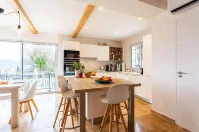 a kitchen with a wooden table and chairs and a counter at LA CASITA VI4348 By Riviera Holiday HOmes in Falicon