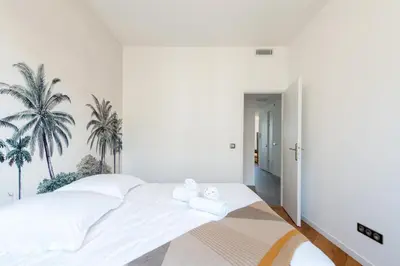 a white bedroom with palm trees on the wall at Happyfew Palazzo del sol in Nice