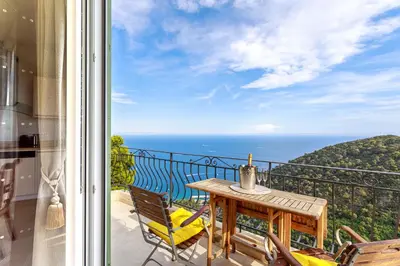a balcony with a table and chairs and the ocean at Sea View Apartment with Private Secure Parking 3 in Villefranche-sur-Mer