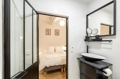 a bathroom with a mirror and a sink and a bed at Chez Collette - Luxury in the Old Nice in Nice