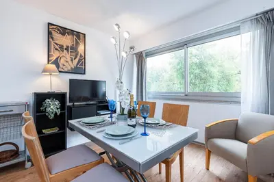 a living room with a table and chairs and a window at Central 1 Bdr in Nice