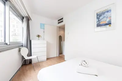 a white bedroom with a white bed and a chair at Central 1 Bdr in Nice