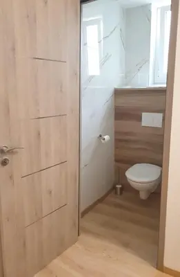 a bathroom with a toilet and a wooden door at LA MAÏOUN DI JOSE - Appt 2 pièces nice centre cœur marché de la libération in Nice