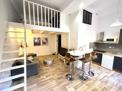 a living room and kitchen with a loft conversion at Studio mezzanine sur le port in Nice