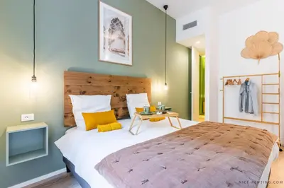 a bedroom with a large bed and a table at Nice Renting - BAVASTRO - Luxurious Loft - 2 BedRoom - AC - Balcony - Trendy Neighborhood in Nice