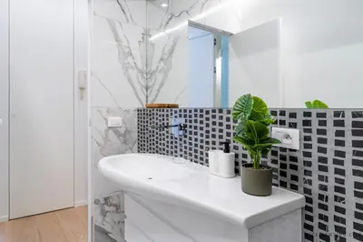 a white bathroom with a sink and a mirror at Nice Renting - BAVASTRO - Luxurious Loft - 2 BedRoom - AC - Balcony - Trendy Neighborhood in Nice