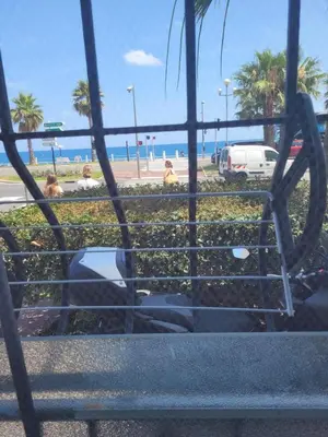 a group of people sitting on a bench near the beach at 2 pièces promenade des anglais in Nice