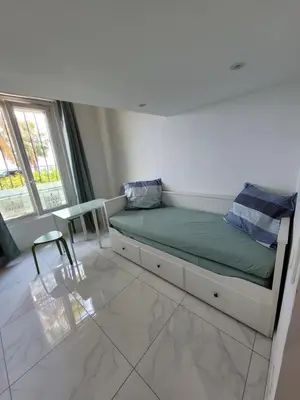 a bedroom with a bed and a table and a window at 2 pièces promenade des anglais in Nice