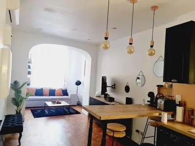 a living room with a table and a couch at Appartement tout confort, agréable à vivre in Nice