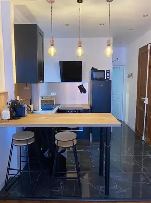 a kitchen with a counter and two stools in it at Appartement tout confort, agréable à vivre in Nice