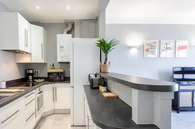 a kitchen with white cabinets and a black counter top at L12 Port window 1Bedroom Wifi 5mins beach & Nice's Cap in Nice