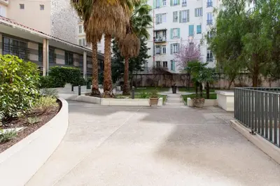 a courtyard with palm trees and a building at L18 Central Parking terrace AC 10mins walk to beaches in Nice
