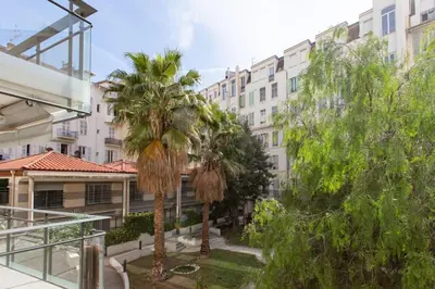 a group of palm trees in front of a building at L18 Central Parking terrace AC 10mins walk to beaches in Nice