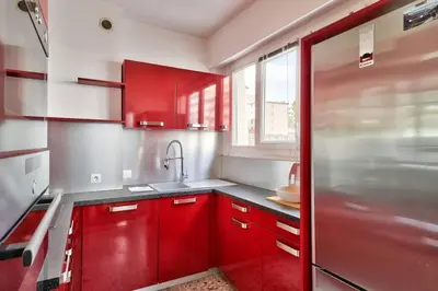a red kitchen with red cabinets and a sink at L29 Lenval beach at 1min walk to Sea front AC Balcony in Nice