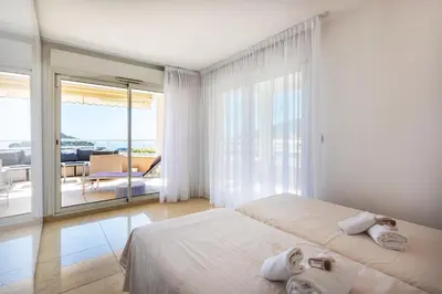 a white bedroom with two beds and a balcony at EZE VISTA AP4328 By Riviera Holiday Homes in Èze