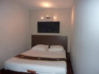 a small bedroom with a bed with white sheets at Vieux Nice 2 pièces Appartement SAN REMO in Nice