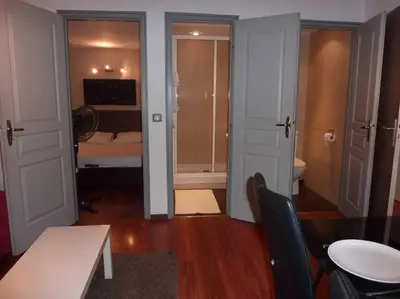 a room with a bedroom with a bed and a table and chairs at Vieux Nice 2 pièces Appartement SAN REMO in Nice