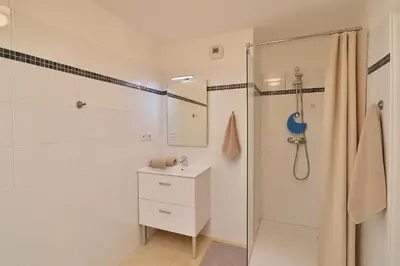 a white bathroom with a shower and a sink at Joli 2 pièces Niçois avec terrasse ensoleillée in Nice