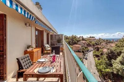 a balcony with a table and chairs on a balcony at L36 Sea view terrace 10min walking to sea/Parking & AC in Nice