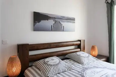 a bed with two pillows and a picture on the wall at L39 Suite Promenade des Anglais, Vue Mer Terrasse&WIFI in Nice