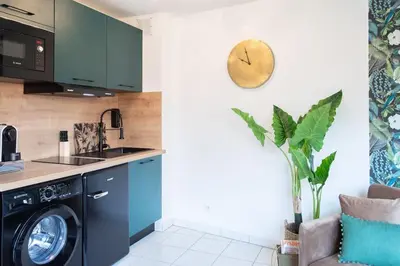 a kitchen with a washing machine and a clock on the wall at L44 1BDR Flat 10mins walk to port/Balcon, Parking, AC in Nice