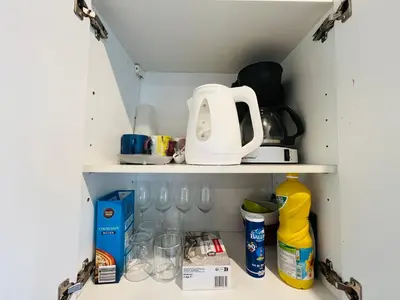 a cupboard with a tea kettle and glasses at Grand studio de 30 m2 Promenade des Anglais in Nice