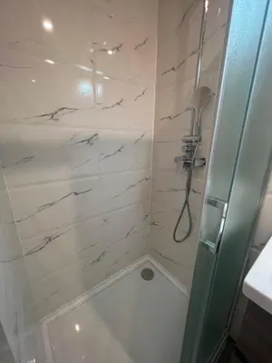 a bathroom with a shower with white marble at La cour du centre Nice Verde in Nice
