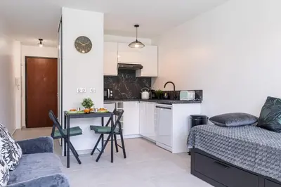 a kitchen and living room with a couch and a table at Pretty Studio Swimming pool and Sea in Cagnes-sur-Mer