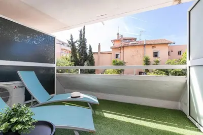 a balcony with a blue chair and a view of a building at Pretty Studio Swimming pool and Sea in Cagnes-sur-Mer