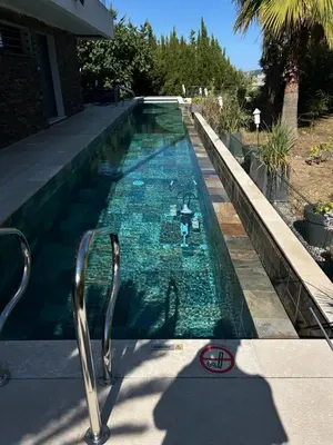 a swimming pool with blue water in a house at COTTAGE MARIN avec VUE MER in Nice
