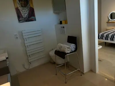 a small bathroom with a toilet and a bed at COTTAGE MARIN avec VUE MER in Nice