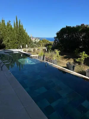 a large swimming pool with a blue at COTTAGE MARIN avec VUE MER in Nice